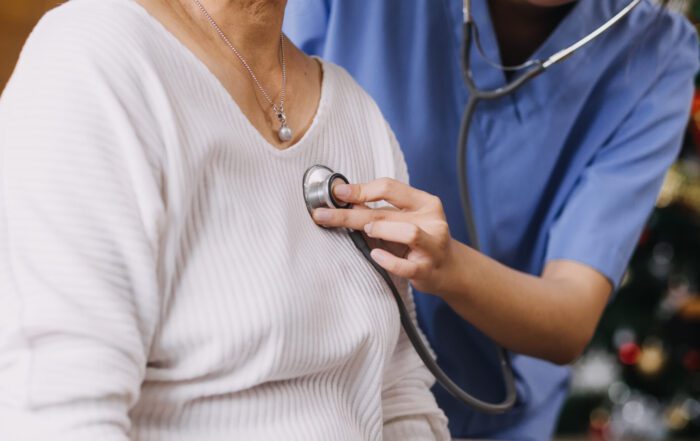 Doctor using a stethoscope on a female patient.