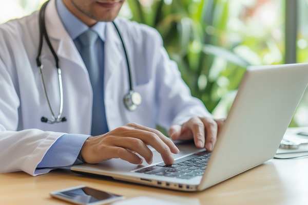 Doctor giving medical consultation while using laptop in clinic workspace