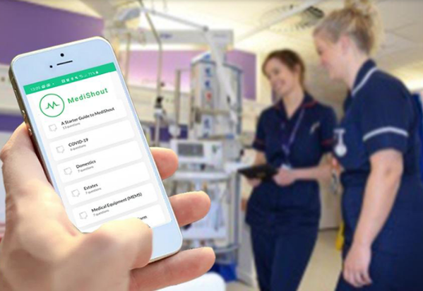 Mobile phone showing the Medishout app open on screen with two nurses in the background